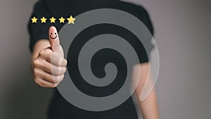 Customer satisfaction concept. Hand with thumb up Positive emotion smiley face icon and five star with copy space