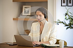 Young woman with headset and laptop working from home