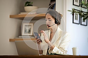 Young woman with headset and laptop working from home