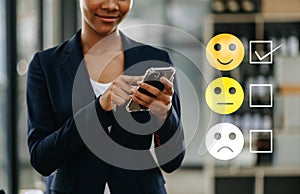 Customer service evaluation concept. woman Show face smile emoticon show on virtual screen from hand.looking at smart phone,