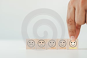 Customer service evaluation and satisfaction survey concept. The client's hand picked the happy face smile face icon