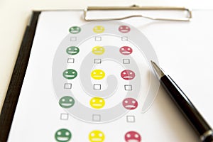 Customer service evaluation survey with smiley faces and pen. photo