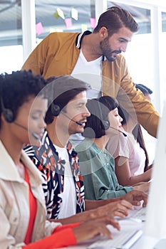 Customer service executive trainer assisting her team at desk