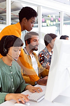 Customer service executive trainer assisting her team at desk