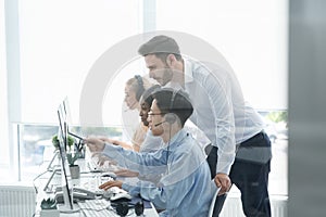 Customer service executive trainer assisting his supervisee at call center office