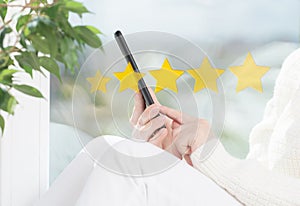 Customer service experience and business satisfaction survey. Woman hand using smart phone with icon five star symbol to increase