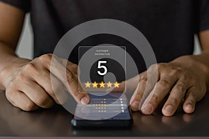 Customer service experience and satisfaction survey concept. Close-up of customer hand giving a five star rating on online