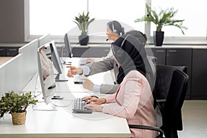 Customer service with friendly, woman call center and operator for support and assistance client looking computer.