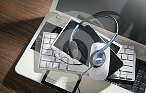 Customer service headset, computer keyboard and business objects on the blue background