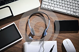 Customer service headset, computer keyboard and business objects on the blue background