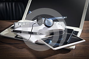 Customer service headset, computer keyboard and business objects on the table