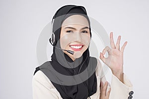 Customer service operator muslim woman in suit wearing headset over white background studio