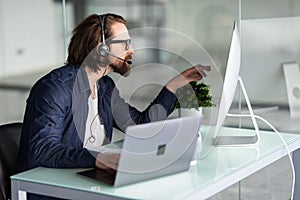 Customer service representative man wearing a headset at the office