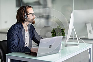 Customer service representative man wearing a headset at the office