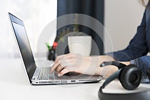 Customer service representative working on laptop at desk in off