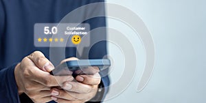 Customer service satisfaction evaluation concept. Man using smartphone and touching on screen with gold five star rating excellent