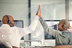 Customer service, team and high five for success with headset at computer for sales or telemarketing. Back of black man