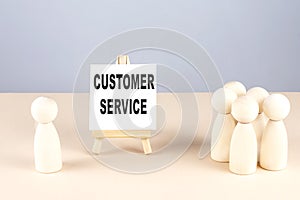 CUSTOMER SERVICE text on a easel with wooden figure, meeting concept