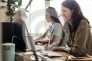 Customer service workers sitting in front of computers working photo