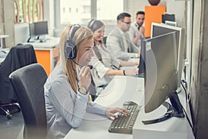 Customer services agents with headset working in a call center.