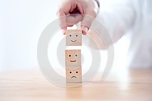 Customer showing rating with happy icon on wood cube, Customer satisfaction survey concept.