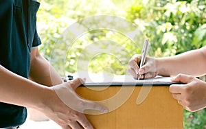 Customer signatures on the clipboard to receive packages from professional delivery staff.