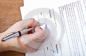 Customer signs a contract by silver pen