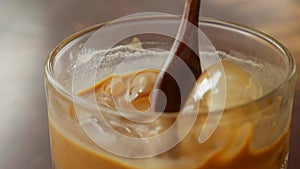 Customer stirring coffee with milk before drinking. Vietnamese Traditional phin Filter in cafe. Ca phe sua da. Close-up