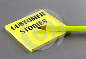 CUSTOMER STORIES text written on a sticky on grey background