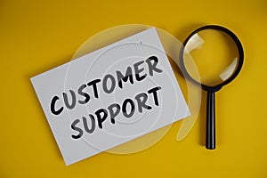 Customer Support letters with magnifying glass flat lay on yellow background