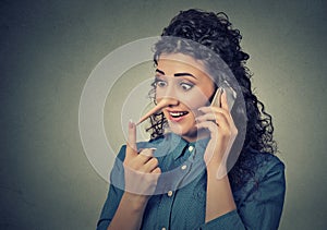 Customer support liar with long nose. Woman talking on mobile phone telling lies