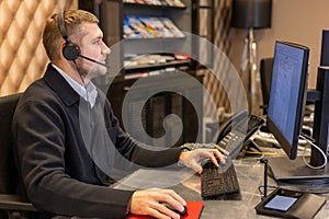 Customer Support Operator Working At Computer With Headset