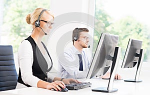 Customer support operators in formalwear working using computers