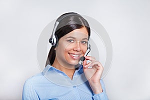 Customer support phone operator in headset, with blank copyspace area for slogan or text message, over grey background