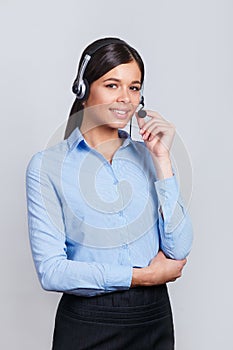 Customer support phone operator in headset, with blank copyspace area for slogan or text message, over grey background