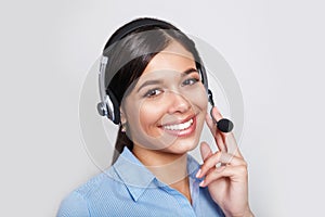 Customer support phone operator in headset, with blank copyspace area for slogan or text message, over grey background