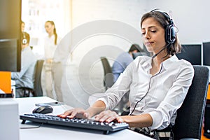 Customer support woman operator being tired after working on computer at her second shift in the office.