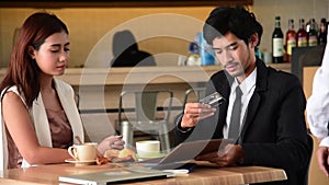 Customer use credit card payment for food at restaurant. Young couple checkout bill and pay via credit to cashier nfc contactless