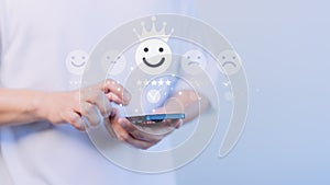 Customer use a smartphone give point the smile face icon for feedback review satisfaction service opinion and testimonial