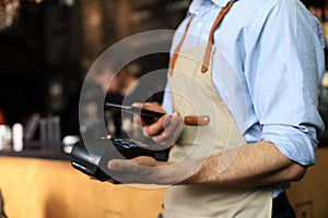 Customer using credit cart for payment to owner at cafe restaurant, cashless technology and credit card payment