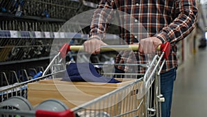 Customer walking with shopping cart in hardware store