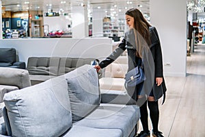 Customer woman buying new furniture - sofa or couch in a store