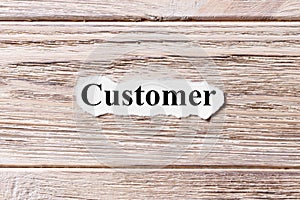 Customer of the word on paper. concept. Words of Customer on a wooden background