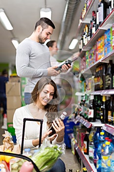 Customers at beverages section of supermarket