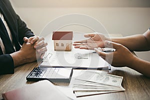 Customers buying houses are negotiating about the cost of home insurance with agents