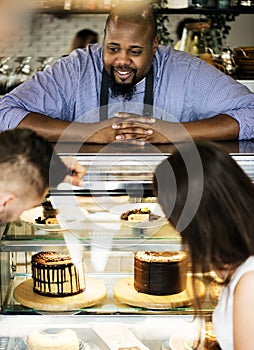 Customers choosing a cake at the display fridge