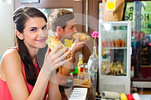 Customers eating Hotdog in fast food snack bar