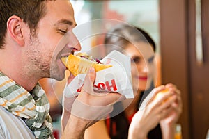 Customers eating Hotdog in fast food snack bar