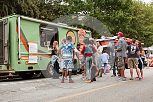 Customers Stand In Line To Buy Meals From Food Trucks