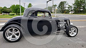 Customized classic lowrider hot rod roadster with exposed engine, big tires